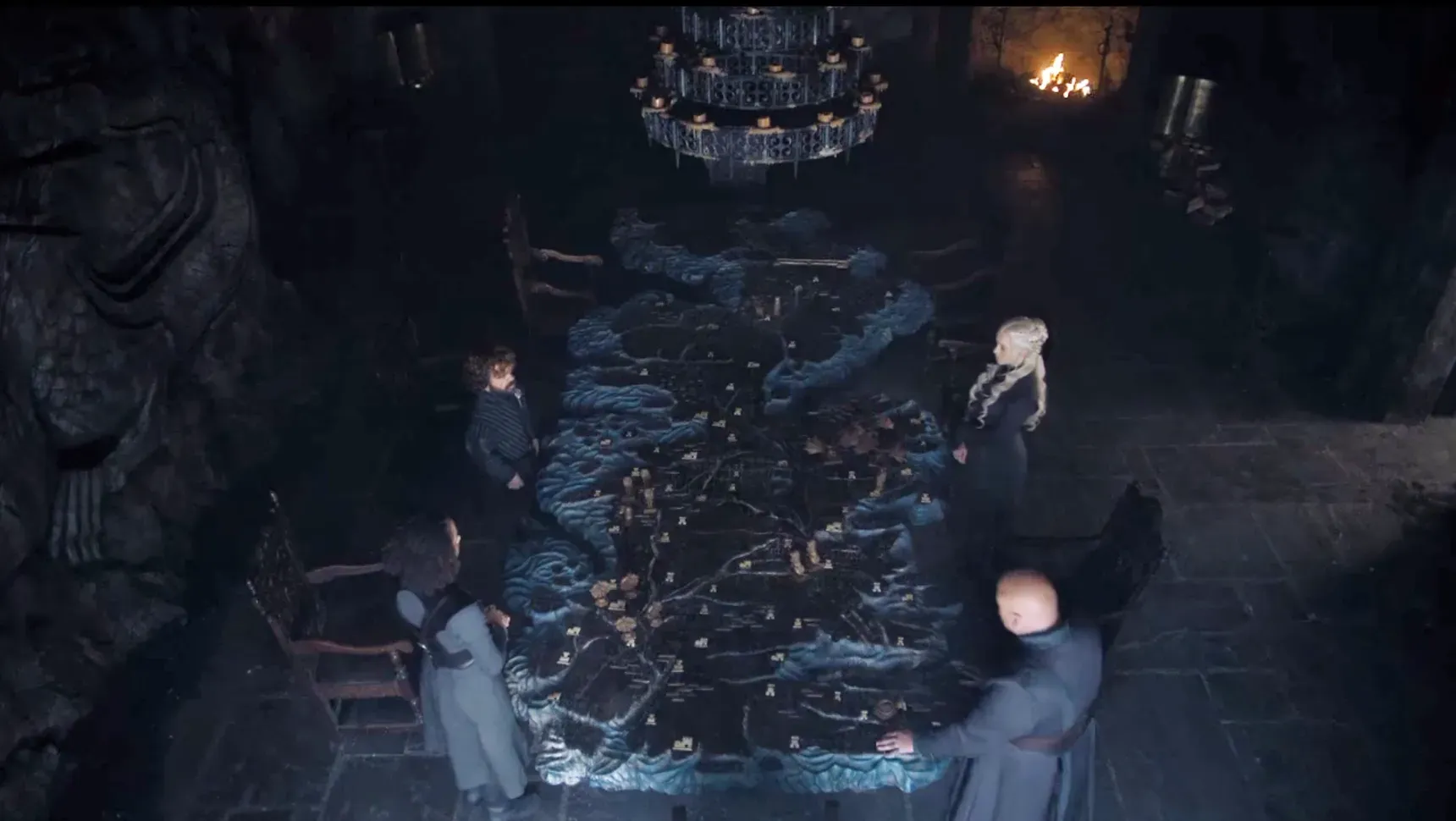 Four people standing around a giant map, aka the map table from the TV show Game of Thrones